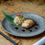 Plate of Japanese-inspired grilled fish on a wood table